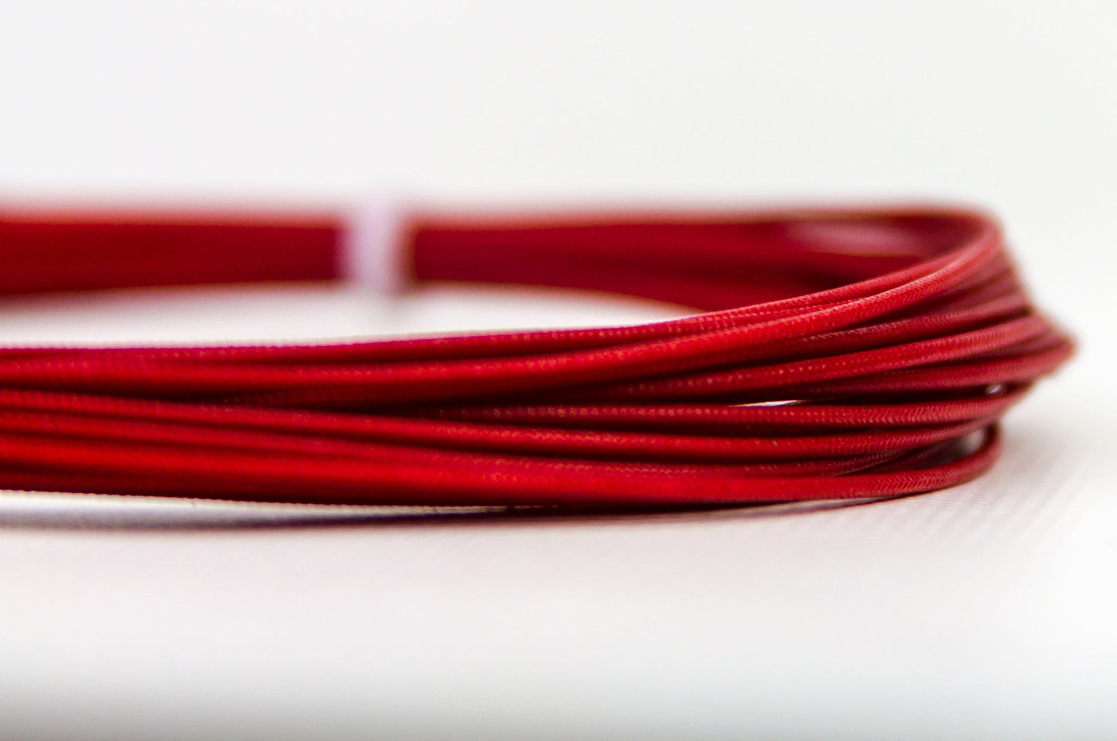 Red coil of cable from [Brand] on white background.